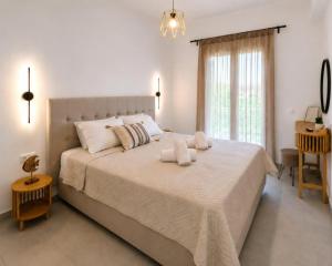 a bedroom with a large bed with two towels on it at Pagonia Apartments in Arillas