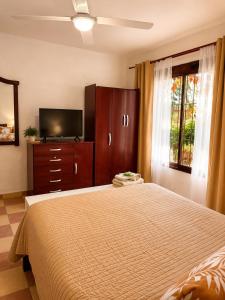 a bedroom with a bed and a flat screen tv at Algarrobos del Mirador in Santa Rosa de Calamuchita