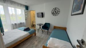 a bedroom with a bed and a chair and a clock at Na Kwiatkowskiego in Sandomierz