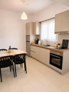 a kitchen with a table and chairs in a room at Pagonia Apartments in Arillas