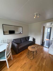a living room with a couch and a table at Leilighet for opptil 4 personer nær Sola flyplass og Stavanger sentrum in Sola