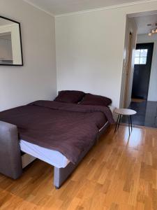 a bedroom with a large bed and a wooden floor at Leilighet for opptil 4 personer nær Sola flyplass og Stavanger sentrum in Sola
