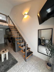 a staircase in a living room with a mirror at 27 Urban Stay in Neochorópoulon