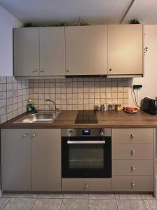 a kitchen with white cabinets and a sink and a stove at 27 Urban Stay in Neochorópoulon