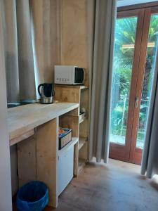 a kitchen with a counter with a microwave and a window at LaTorrettaLoano Affittacamere in Loano