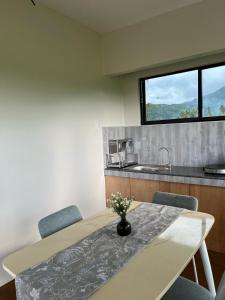 a dining room with a table and chairs and a window at Mystical Hidden Farmhouse in Mahinog