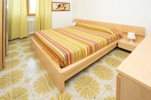 a bedroom with a bed with a striped blanket at Residence Baia degli Sciti in Torre a Mare +19 photos