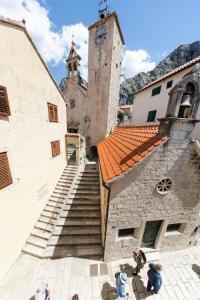 an old building with a clock tower and stairs at Hotel Corsaro in Omiš