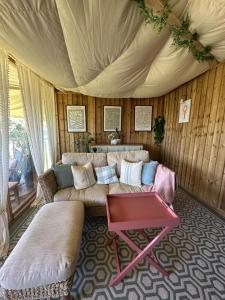 a living room with a couch and a table at Tregantle Farm Eco GLAMPSITE in Torpoint
