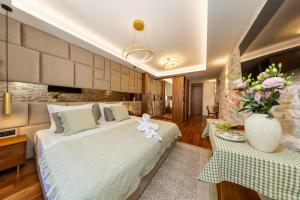 a bedroom with a large bed and a vase of flowers at Hotel Corsaro in Omiš