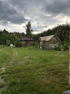 a woman standing in a yard in front of a house at Leśna Polana in Józefów +4 photos