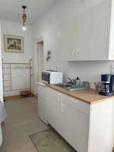 a white kitchen with a sink and a microwave at Above the Sea - Sparto in Spartos