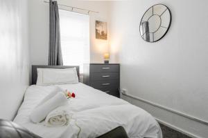 a bedroom with a bed with a clock on the wall at Denton Luxury Home - Sleep 8 - Speedy Wi-Fi - Free On-Site Parking in Denton