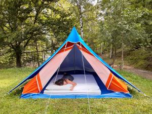 a person laying in a tent in the grass at Il glomere - campeggio di Rorà in Rorá