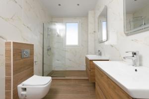 a bathroom with a toilet and a sink and a shower at VILLA TOSTi & VILLA JOY in Skala Rachoniou +49 photos