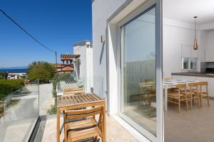 a room with a balcony with a table and chairs at VILLA TOSTi & VILLA JOY in Skala Rachoniou