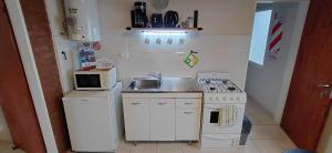 a small kitchen with a sink and a stove at CALAFATE CENTER APARTS in El Calafate +9 photos