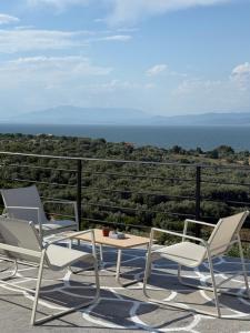 two chairs and a table on a patio with the ocean at Above the Sea - Sparto in Spartos