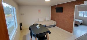 a small room with a bed and a table in it at CALAFATE CENTER APARTS in El Calafate