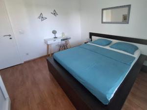 a bedroom with a bed with blue sheets and a mirror at Apartment Računica in Vodice