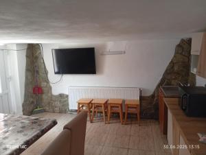 a living room with a table and a tv on the wall at Casa Drăgan in Novaci-Străini