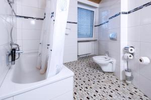 a white bathroom with a toilet and a shower at Hotel Starkenburger Hof in Heppenheim an der Bergstrasse