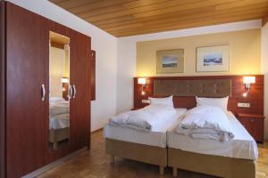 a bedroom with two beds and a mirror at Hotel Starkenburger Hof in Heppenheim an der Bergstrasse