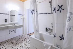 a bathroom with a tub and a sink at Hotel Starkenburger Hof in Heppenheim an der Bergstrasse