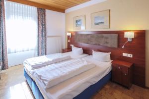 a bedroom with two beds and a large window at Hotel Starkenburger Hof in Heppenheim an der Bergstrasse +13 photos