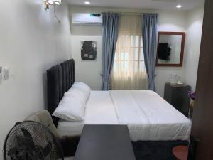 a hotel room with a bed and a window at Pointax Apartment Lekki in Ilado