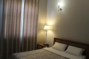 a bedroom with a bed and a lamp next to a window at Strong Five apartment in Sumy
