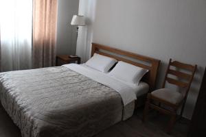 a bedroom with a large bed and a chair at Strong Five apartment in Sumy