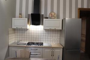 a kitchen with a refrigerator and a sink at Strong Five apartment in Sumy