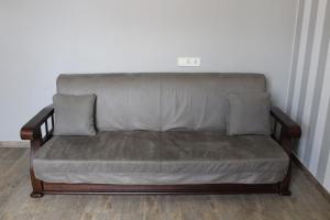 a couch with two pillows sitting in a room at Strong Five apartment in Sumy