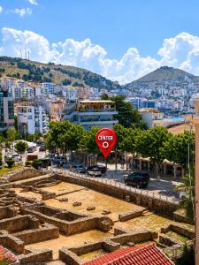 a red stop sign in front of a city at RAI Rooms Saranda in Sarandë