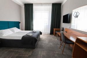 a hotel room with a bed and a desk at Green Hotel in Świebodzin