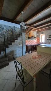 a room with a table and chairs and a staircase at Pr' Tekcu in Dekani