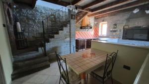 a kitchen with a table and a stone wall at Pr' Tekcu in Dekani +16 photos