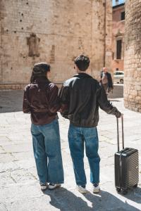a man and woman walking down a street with a suitcase at Paradise Rooms in Bitritto