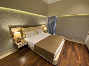 a bedroom with a bed and a night stand with a lamp at Absheron Marina in Baku +46 photos