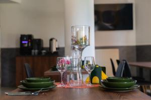 a table with glasses and a vase on top of it at Green Hotel in Świebodzin