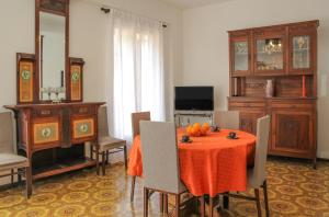 comedor con mesa, sillas y TV en Naxos Holiday Apartment, en Giardini Naxos