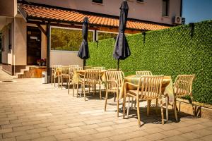 a row of tables and chairs with umbrellas at Villa Irina in Ohrid