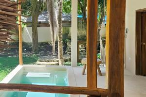 a hot tub in a room with a window at CASA 2 HAB Alberca y Parking privado in Bacalar