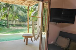 a room with a tv and a chair and a window at CASA 2 HAB Alberca y Parking privado in Bacalar