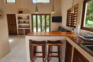 a kitchen with a counter and two stools at a bar at CASA 2 HAB Alberca y Parking privado in Bacalar