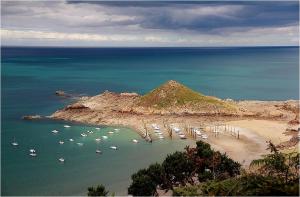 a group of boats in the water on a beach at le Questel in Plouézec