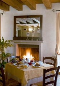 una sala da pranzo con tavolo e camino di Hotel Villa Dei Carpini a Oderzo