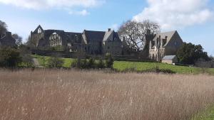 an old castle on a hill with a field of grass at le Questel in Plouézec +4 photos