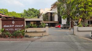 a street with a hotel kmon sign on a building at Hotel Ikon in Hubli